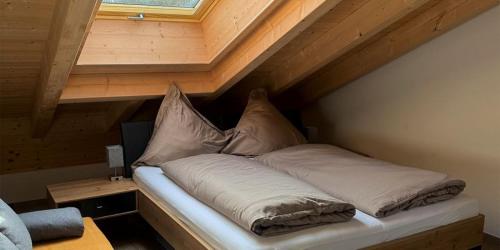 a bed with pillows on it in a attic at Alpenchalets Zugspitze in Grainau