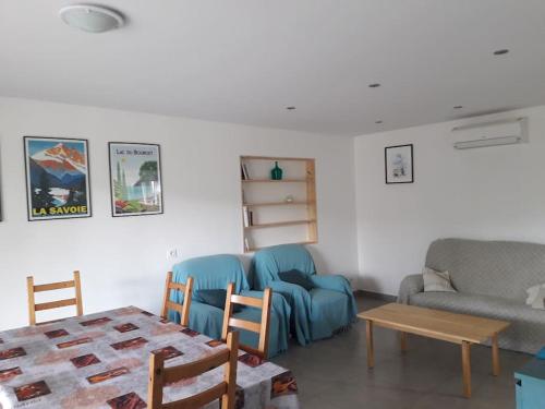 un salon avec un canapé bleu et une table dans l'établissement Le Jirani 90m2 calme jardin privé proche Le Phare, à Chambéry