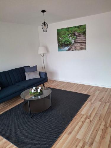 a living room with a blue couch and a table at Schöne Wohnung mit Balkon in Stockach