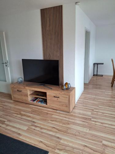 a living room with a flat screen tv on a wooden entertainment center at Schöne Wohnung mit Balkon in Stockach