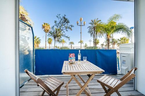 - une table en bois et 2 chaises sur la terrasse dans l'établissement Cosy 2P Promenade des Anglais, à Nice