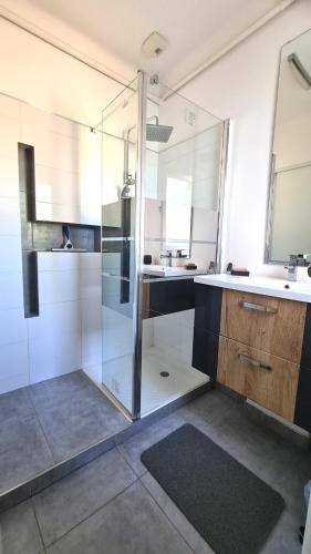 une salle de bain avec une douche en verre et un lavabo dans l'établissement Jolie villa loc-saisonnière - la petite cocagne, à Alleins