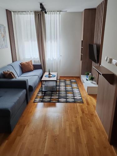 a living room with a couch and a table at Brzece lux apartman in Brzeće