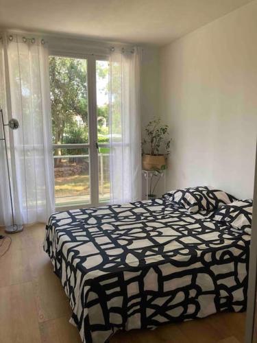 une chambre avec un lit noir et blanc et une fenêtre dans l'établissement Flat air conditioning 4 people near stadium beach, à Marseille