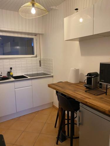 une cuisine avec des armoires blanches et un comptoir en bois dans l'établissement Studio Cosy Illkirch, à Strasbourg