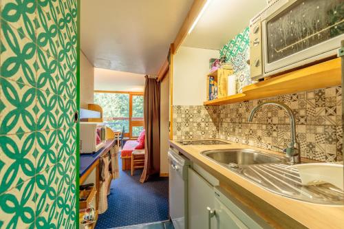 une cuisine avec un évier et un micro-ondes dans l'établissement Studio Centre Station les Arcs 1800, à Bourg-Saint-Maurice