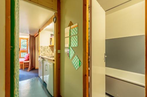 un couloir avec une porte menant à une cuisine dans l'établissement Studio Centre Station les Arcs 1800, à Bourg-Saint-Maurice