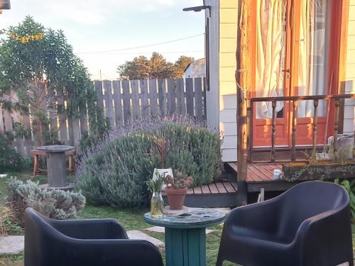 a patio with two chairs and a table at Tiny house Refugio santa isabel in Colonia Chapadmalal
