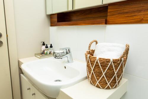 a bathroom with a sink and a basket on the counter at Zimbali Suites 320 in Ballito