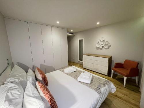 a bedroom with a white bed and a red chair at Hortas Residence 13 in Funchal