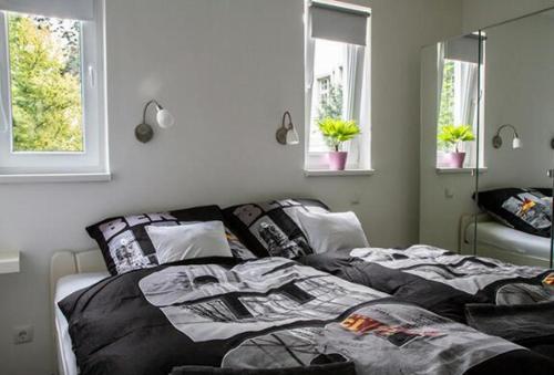 a bedroom with a bed and two windows at BerLietz in Berlin