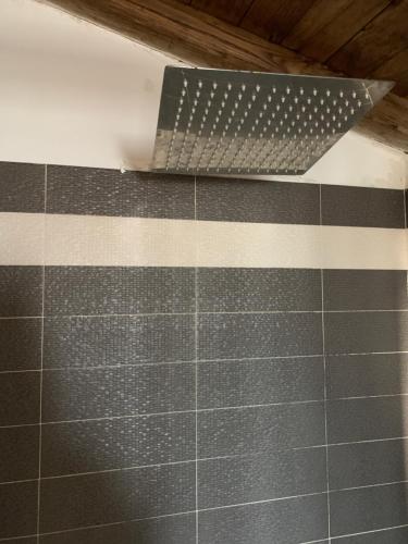 a bathroom with a tile wall with a metal comb at Ortaccio relais & private SPA in Vasanello