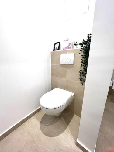 une salle de bain avec des toilettes blanches dans une chambre dans l'établissement Votre Pied-à-Terre Idéal à Montmartre !, à Paris