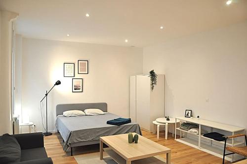 une chambre avec un lit, un canapé et une table dans l'établissement Votre Pied-à-Terre Idéal à Montmartre !, à Paris