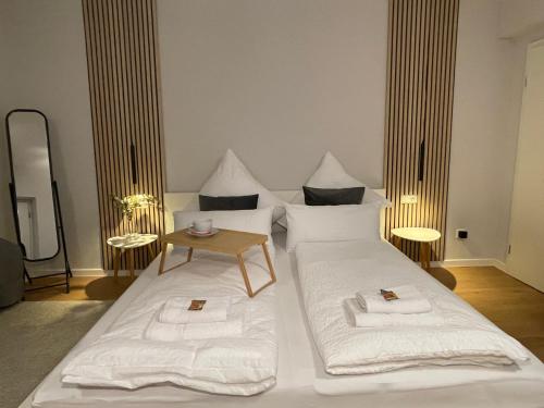 a bedroom with a bed with white sheets and a table at Nice City Apartment in Nürnberg
