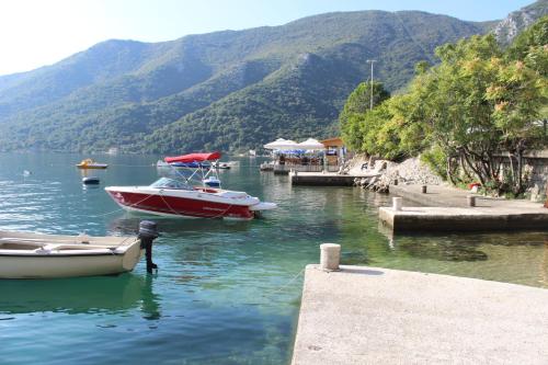 two boats are docked in a body of water at Apartments Mijuskovic in Donji Morinj