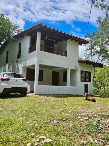 a white car parked in front of a house at Tranquilidad y Naturaleza Cabaña Concepción in Concepción