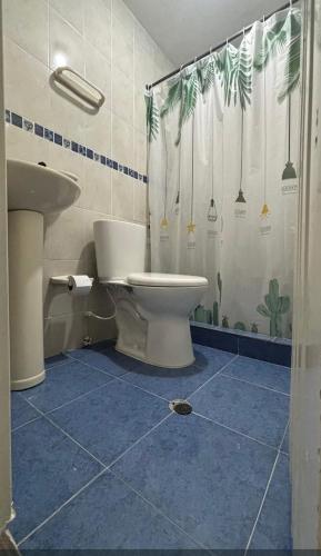 a bathroom with a toilet and a shower curtain at james house in Cali