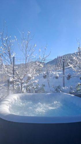 a jacuzzi tub in a yard with snow on the ground at Stone Chalets - TERRA in Jajce