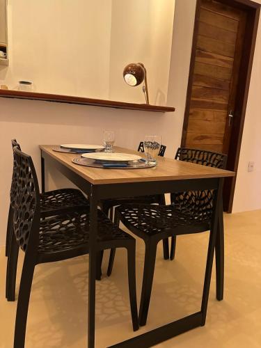 a dining room table with two chairs and a lamp at Tatajuba Flats in Tatajuba