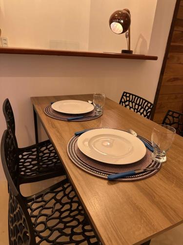 a wooden table with chairs and plates on it at Tatajuba Flats in Tatajuba