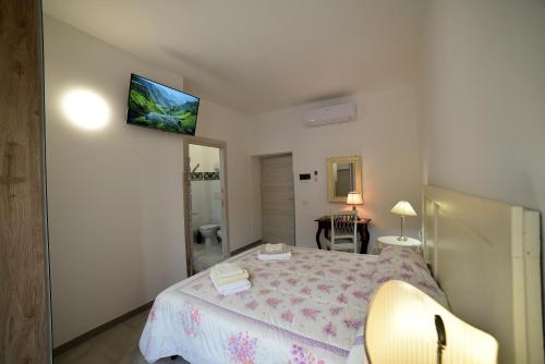 a bedroom with a bed and a television on the wall at Il Palazzetto in Bolsena