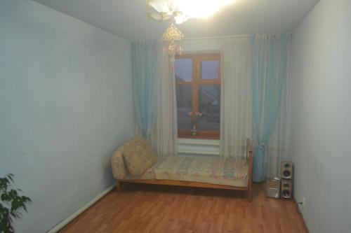 een woonkamer met een stoel en een raam bij Run İn Joy Hostel in Qostanaj