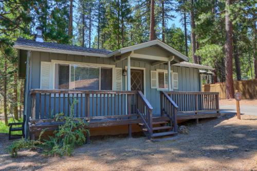 a small house with a large porch in the woods at 17C The Redwoods Cabin in North Wawona