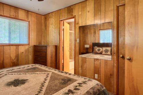 a bedroom with wooden walls and a bed and a window at 17C The Redwoods Cabin in North Wawona