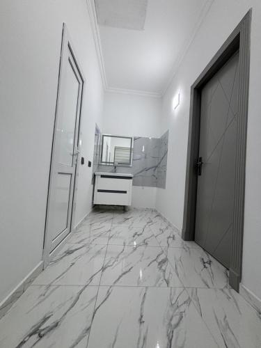 a bathroom with a marble floor and a door at Shahdag S&R House in Qusar