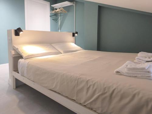 a bedroom with a white bed with towels on it at Appartamento Hokusai in Brescia