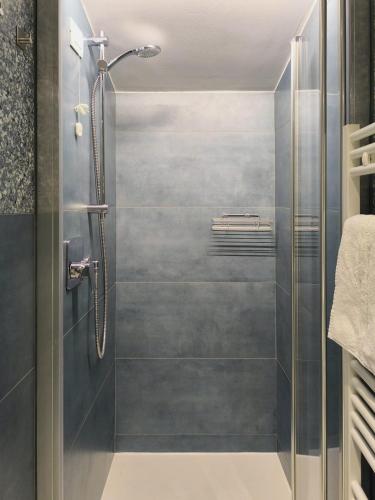 a shower with a glass door in a bathroom at Appartamento Hokusai in Brescia