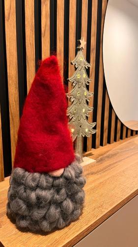 a santa hat sitting on a bench next to a christmas tree at Rezidencia pod Zámkom Bojnice Apartmán Luna in Bojnice
