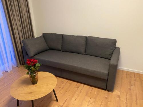 a living room with a couch and a table with a vase of flowers at Apartments Y Edelhof in Saalfeld