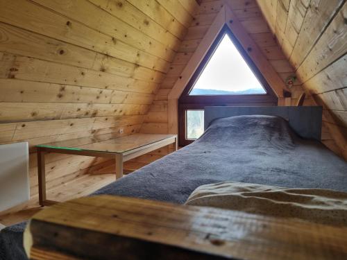 a bedroom in a log cabin with a window at Kutak Maša in Rudno