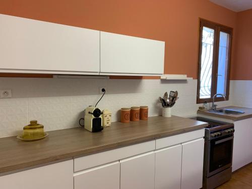 une cuisine avec des armoires blanches et un comptoir en bois dans l'établissement Maison indépendante Haute-Corse mer et montagne, à Santo-Pietro-di-Tenda