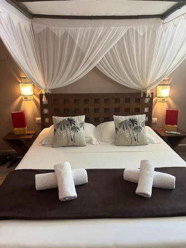 a bedroom with a bed with two towels on it at Domaine de l'Anse des Rochers in Saint-François