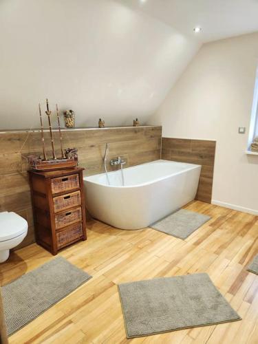 a bathroom with a white tub and a toilet at Maison chez Jacky au calme avec parking Deux salles de bain in Soufflenheim