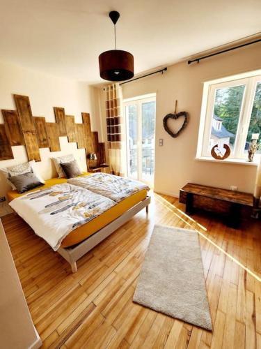 a bedroom with a bed with a wooden headboard and windows at Maison chez Jacky au calme avec parking Deux salles de bain in Soufflenheim