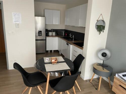 une cuisine avec une table et des chaises dans une cuisine dans l'établissement Patbad85, à La Roche-sur-Yon