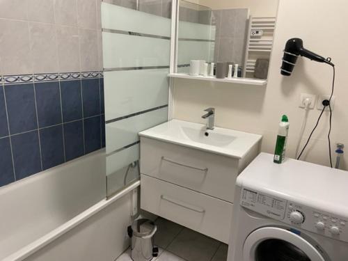 une salle de bain avec un lavabo et une machine à laver dans l'établissement Patbad85, à La Roche-sur-Yon