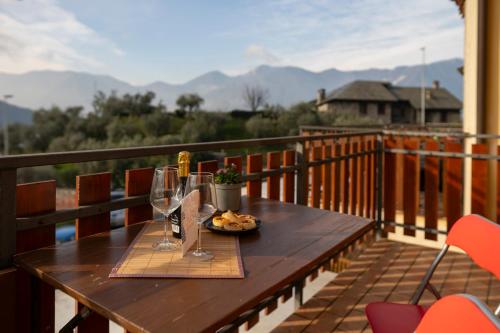 a table with wine glasses and a plate of food on a balcony at Lago di Sole X 6 Point Break in Marone