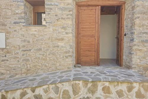 una entrada a un edificio de piedra con puerta de madera en La Era de Lardiés, en Lardiés