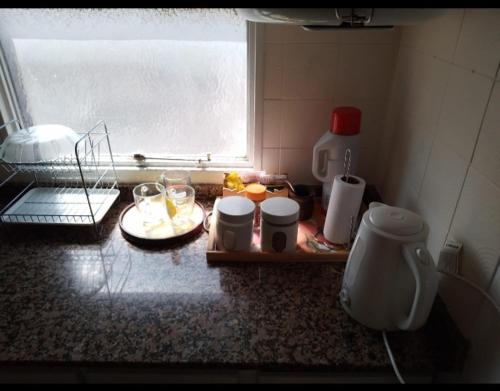 a kitchen counter with a tray of food and a window at Departamento Céntrico Zona Basílica de Luján in Luján