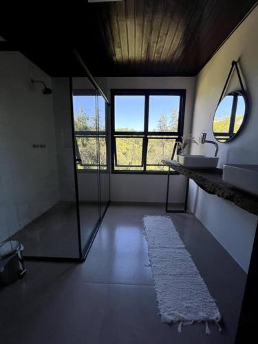 a large bathroom with a sink and a mirror at Chácara da Aráucária - sítio privativo com piscina, churrasqueira e área verde in Presidente Lucena