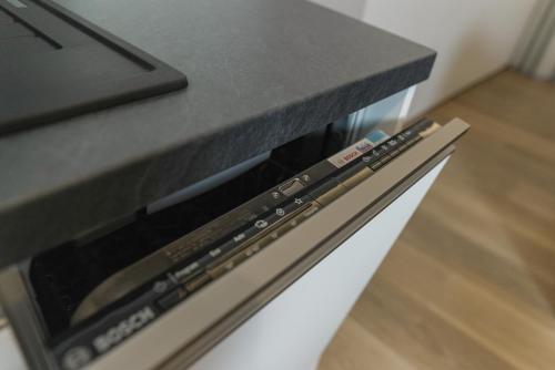 a black counter top on top of a dishwasher at Summit of Saxony Resort Oberwiesenthal in Kurort Oberwiesenthal