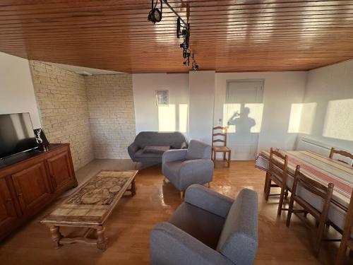 Il comprend un salon doté d'une télévision, de chaises et d'une table. dans l'établissement font romeu, à Font-Romeu-Odeillo-Via