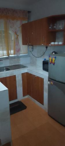 a kitchen with wooden cabinets and a refrigerator at Serena beach villas in Mombasa