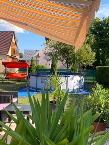 an orange canopy over a patio with plants at Pipacs vendégház in Harkány