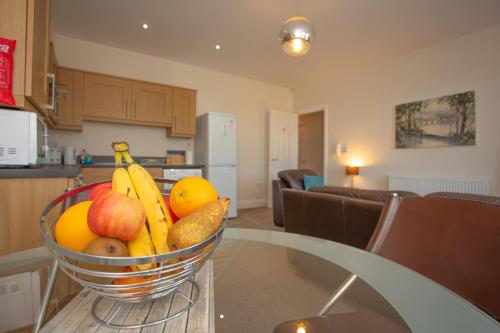 a basket of fruit on a table in a kitchen at Norton Serviced Apartments in Stockton-on-Tees